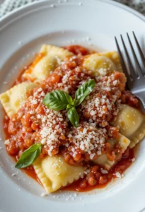 plated ravioli with marinara and basil
