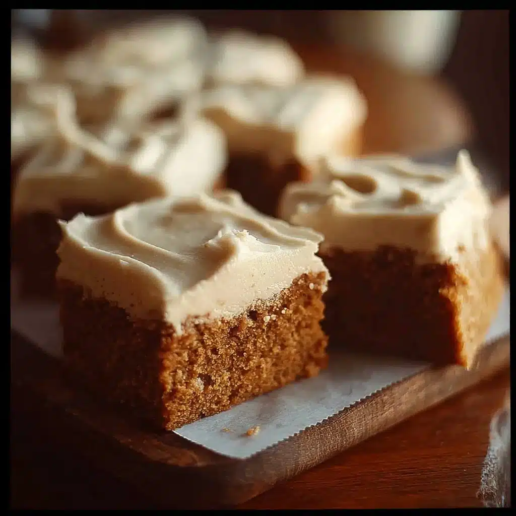 Delicious pumpkin bars topped with rich brown sugar frosting on a wooden table.