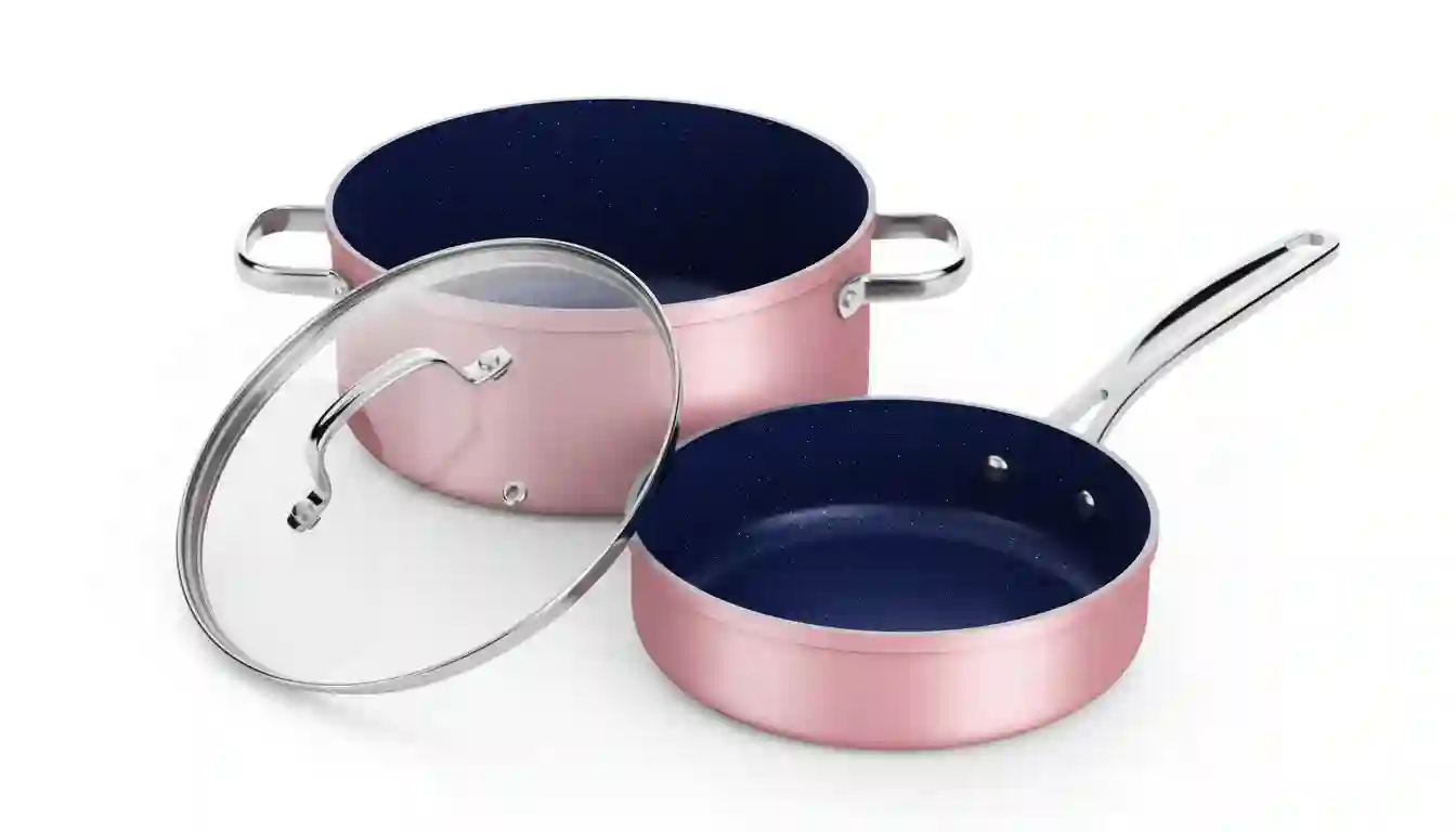 “Dusty pink ceramic nonstick cookware set with glass lids on kitchen table”