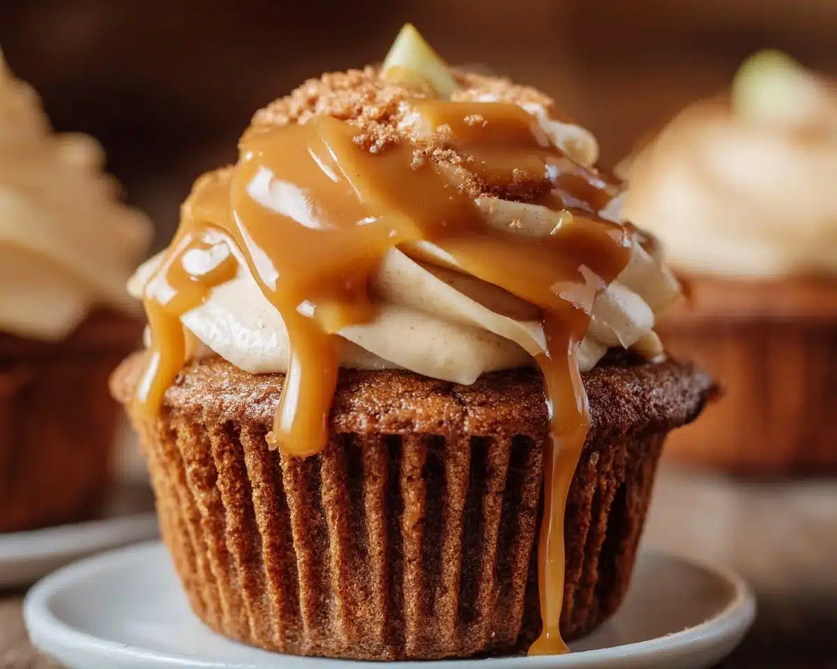 Delicious caramel apple cupcakes topped with caramel drizzle and apple pieces