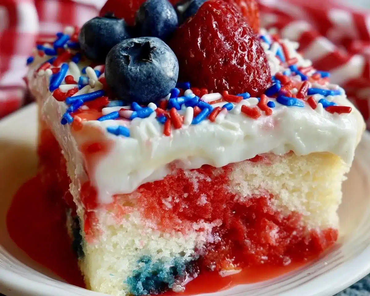 Patriotic Poke Cake topped with red, white, and blue berries for a festive celebration