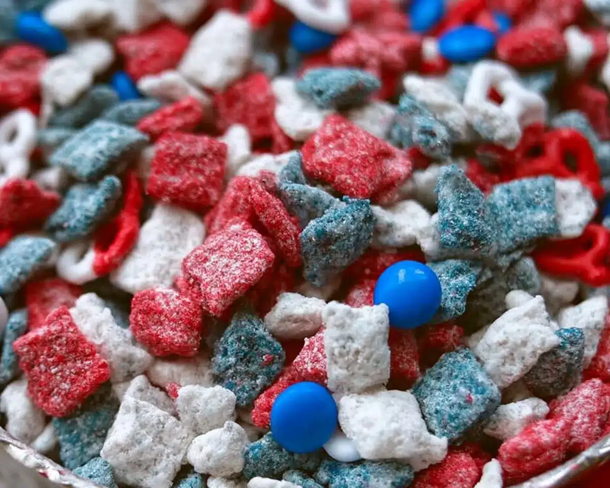 Bowl of Red White & Blue Puppy Chow snack mix with festive colors