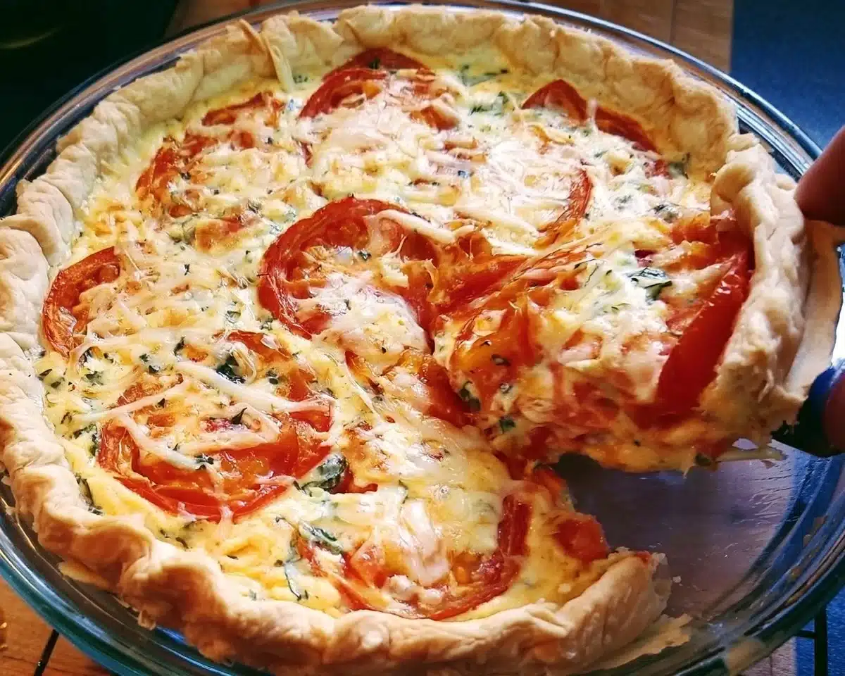 Homemade tomato pie topped with fresh herbs and cheese